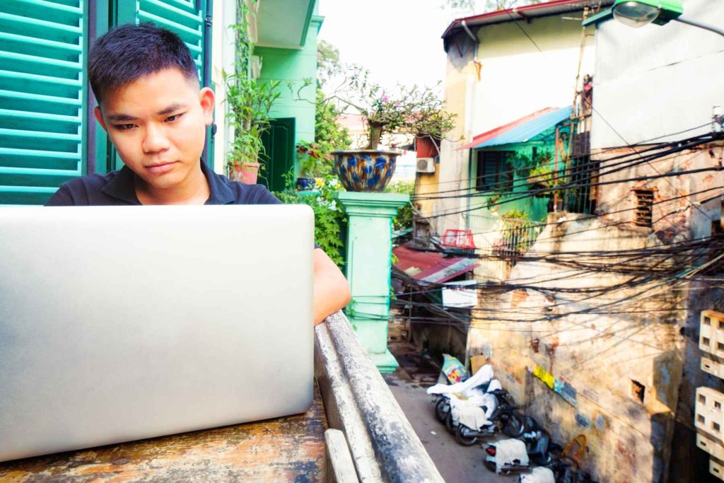 Person on their computer outside above the street