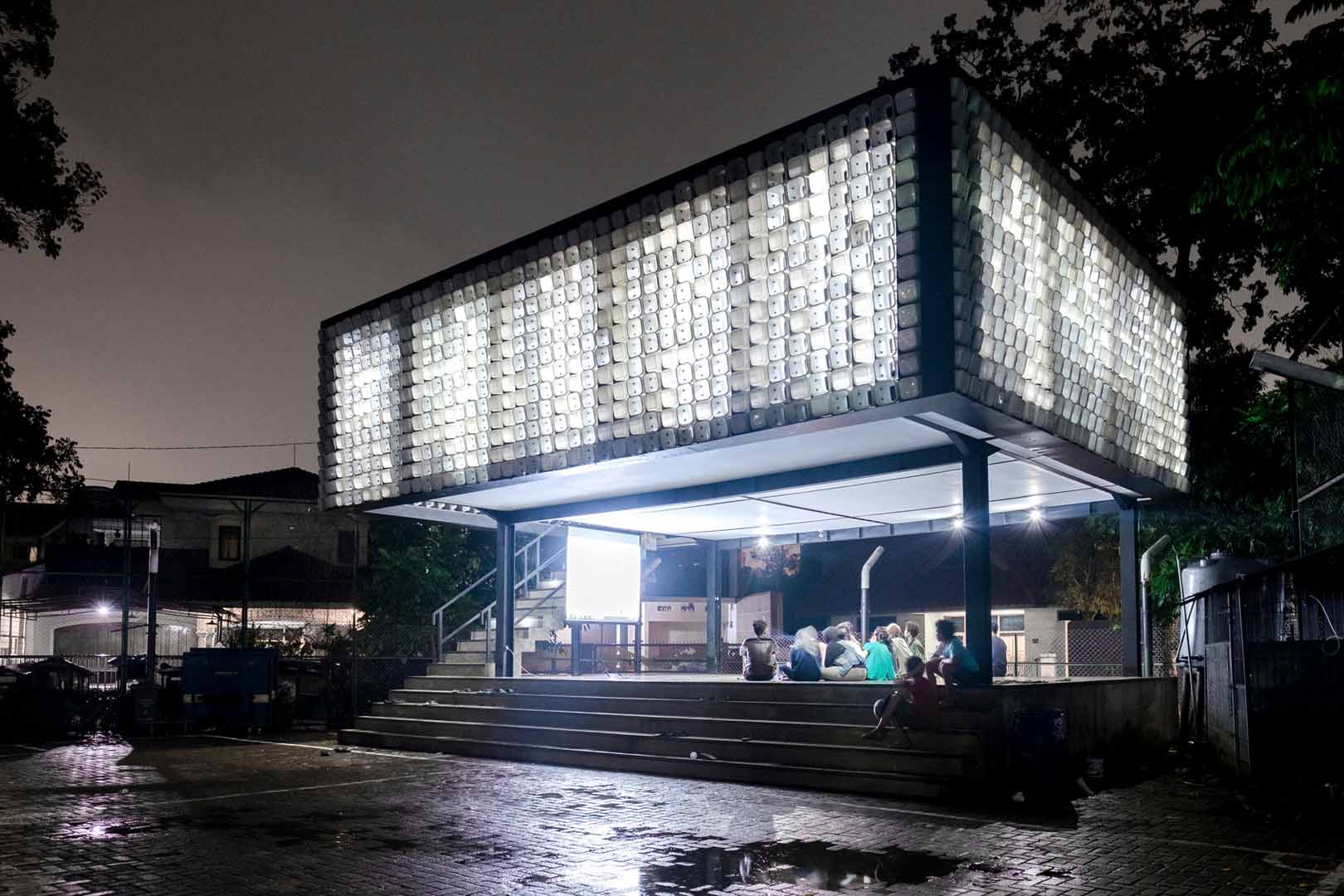 Bright elevated building with people sitting underneath