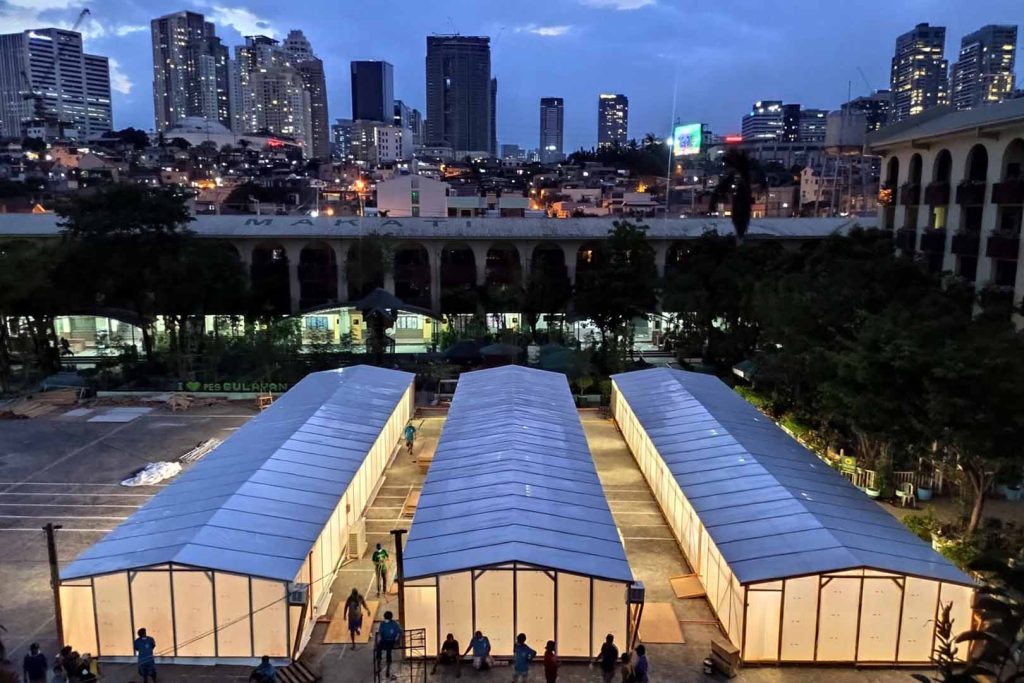 Three long buildings with a skyline in the background