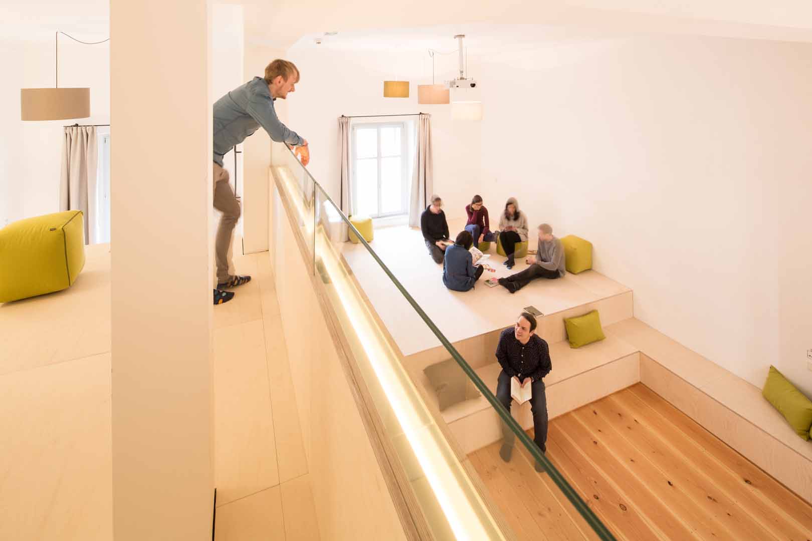 A person upstairs speaking with a group of people below