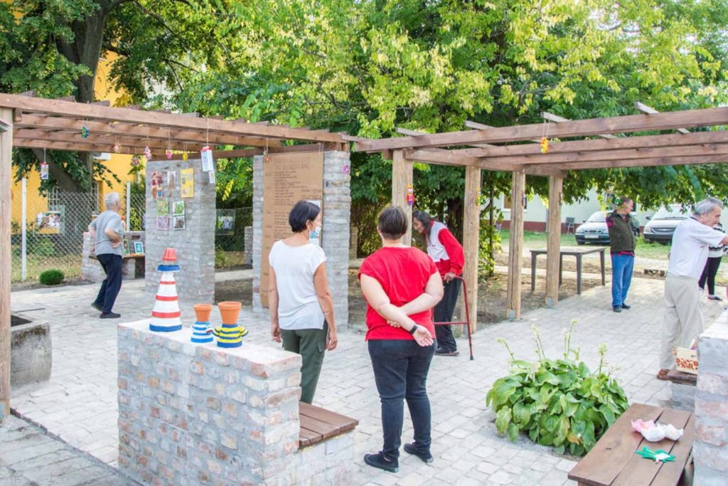 Shot of gazebo with people gathered and socializing in the center