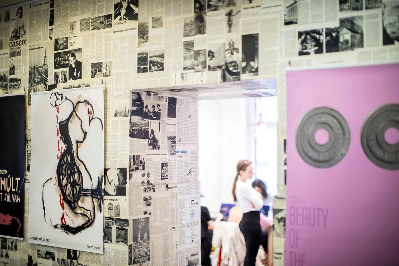 Wall of artwork in foreground with door looking into classroom in the background