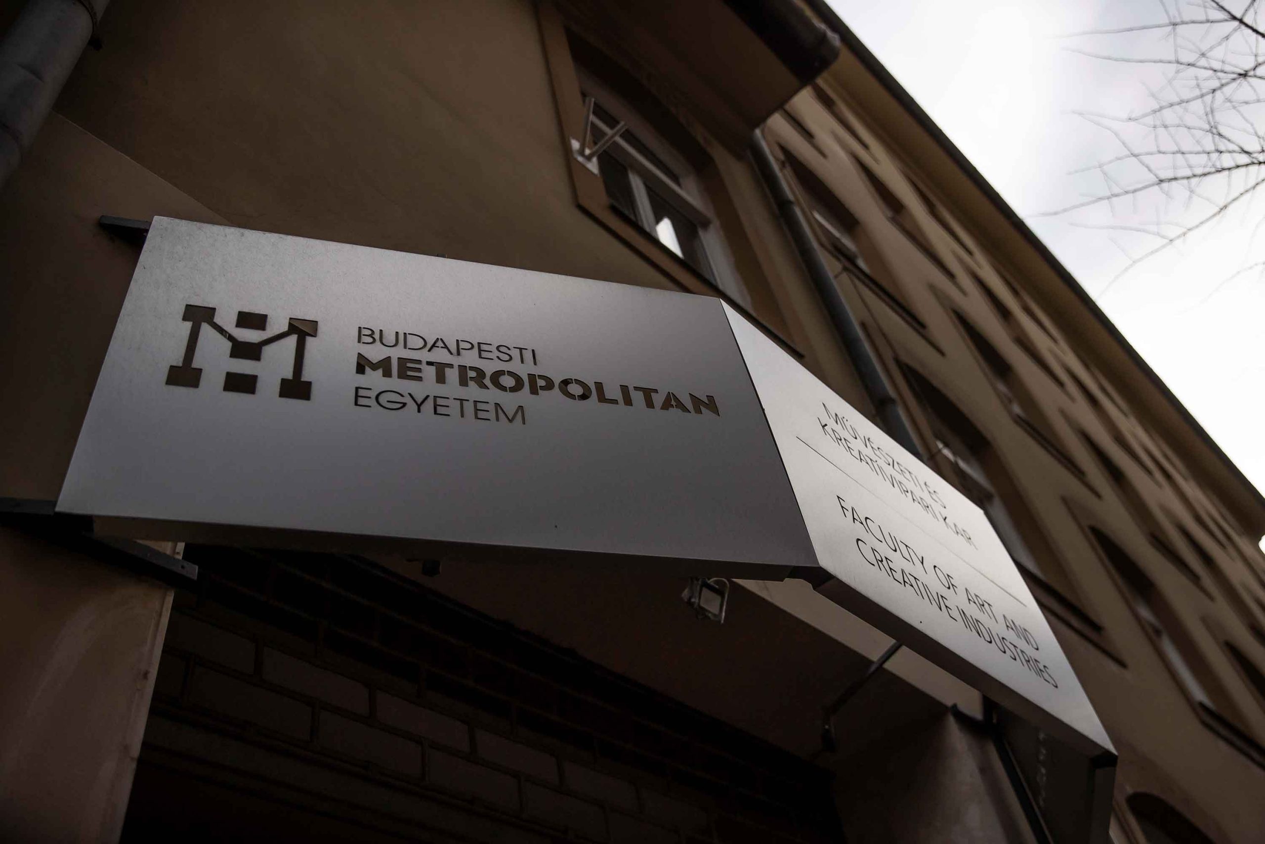 Upwards shot of Budapest Metropolitan University sign in front of a building